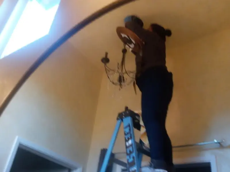 Electrician installing a chandelier in a El Granada residence